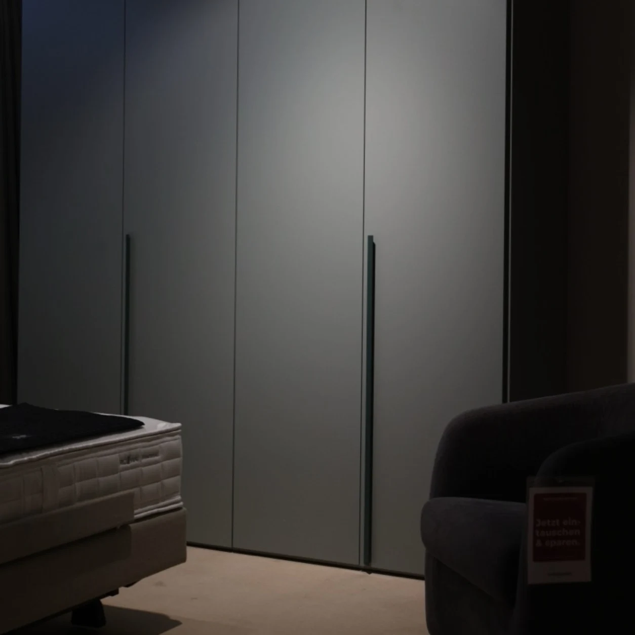 Schlafzimmer mit dunklem Kleiderschrank und Bett