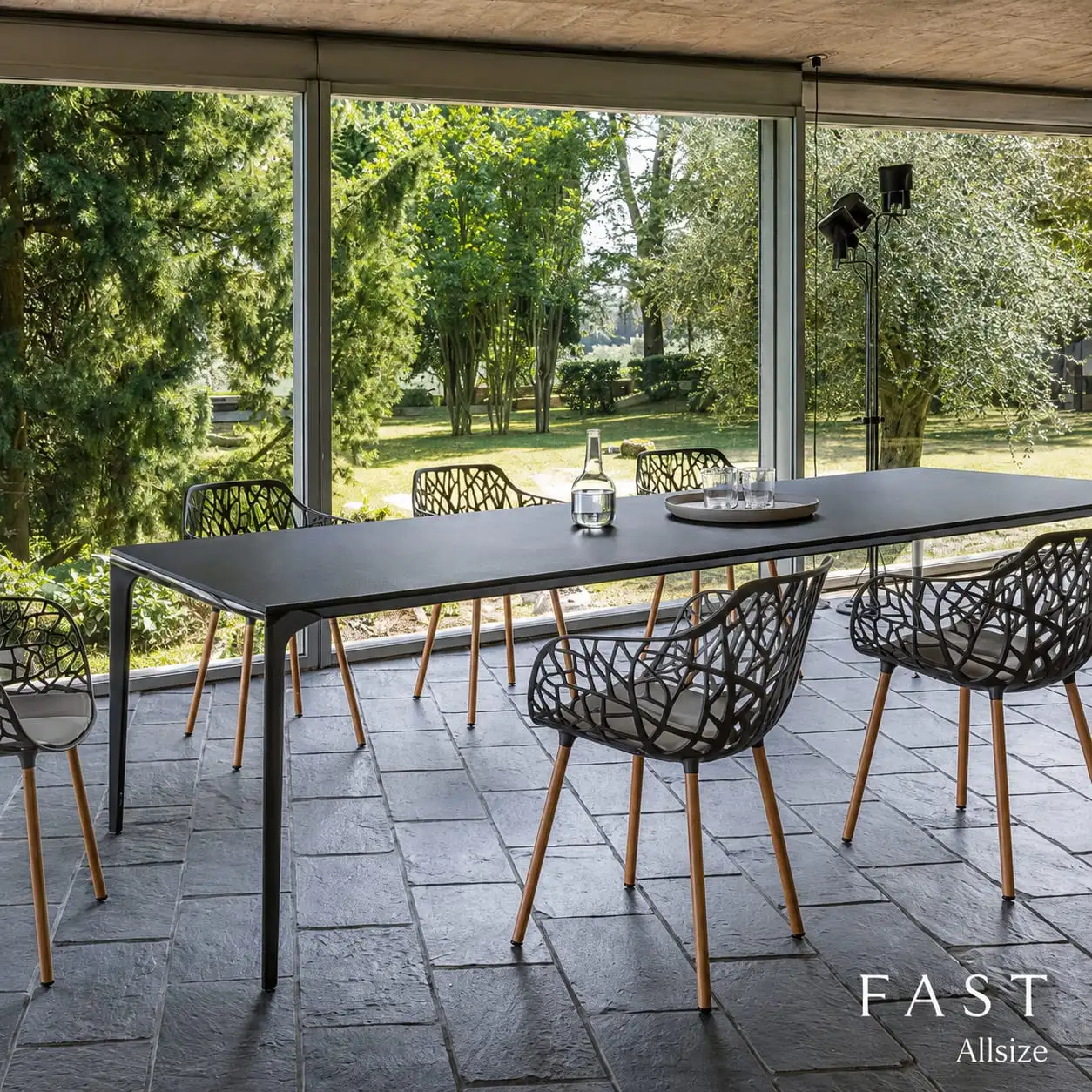 Langer Outdoor-Tisch mit Designstühlen auf einer Terrasse