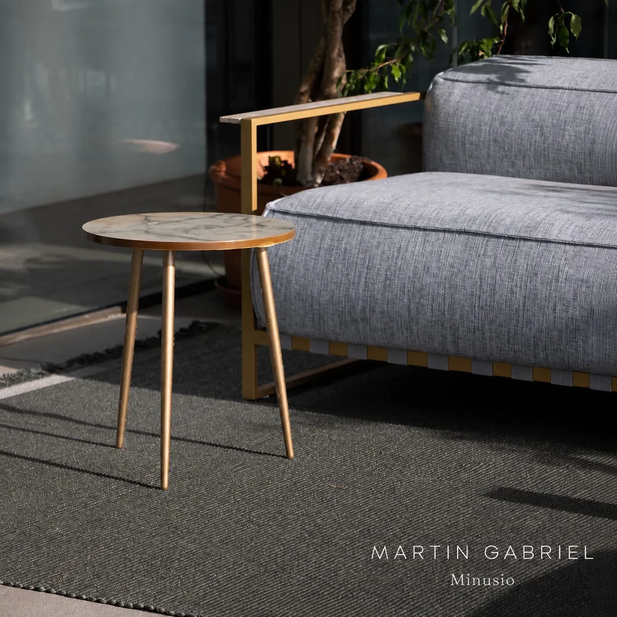 Graues Sofa mit Beistelltisch auf modernem Teppich
