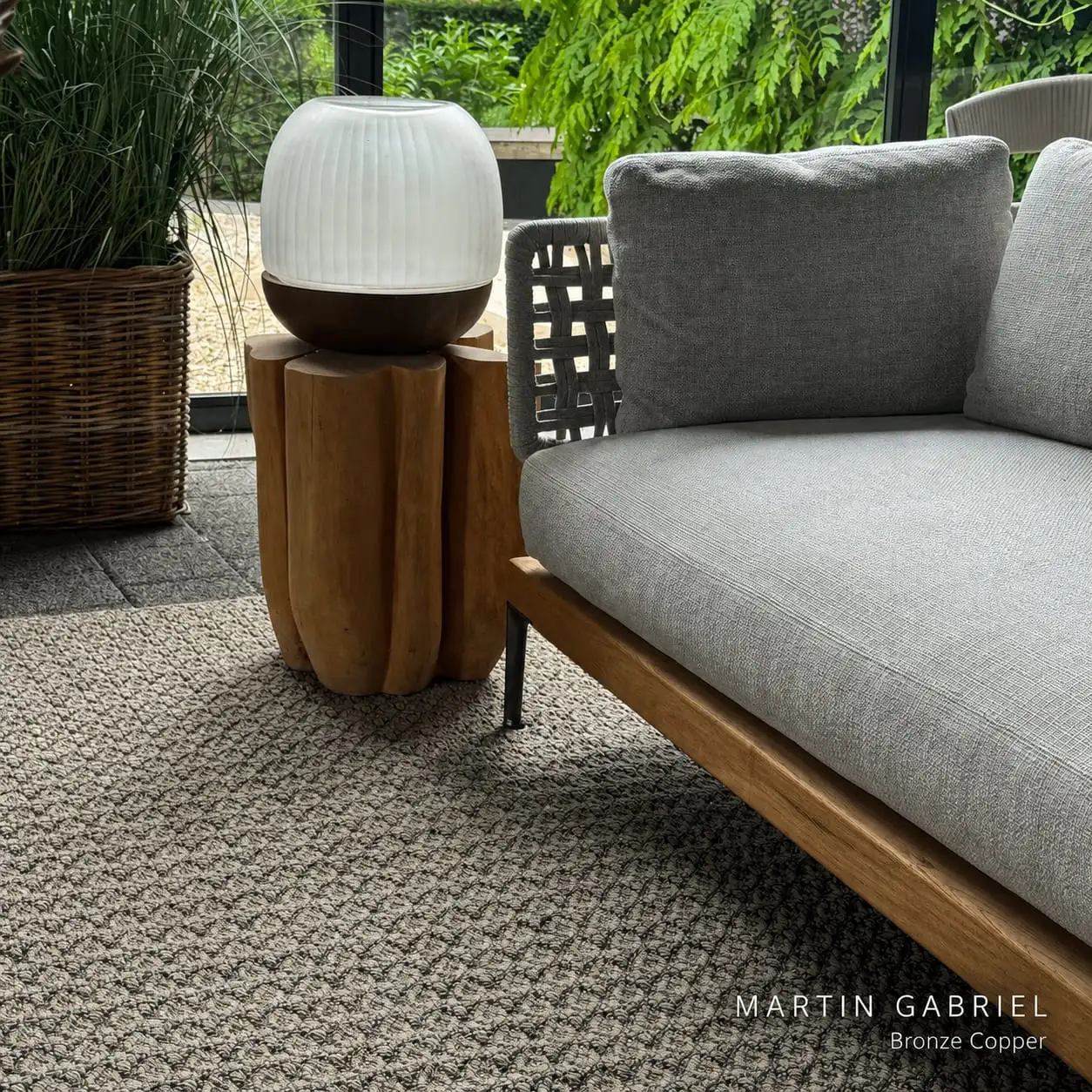 Outdoor-Sofa mit Teppich, Kissen und dekorativer Leuchte